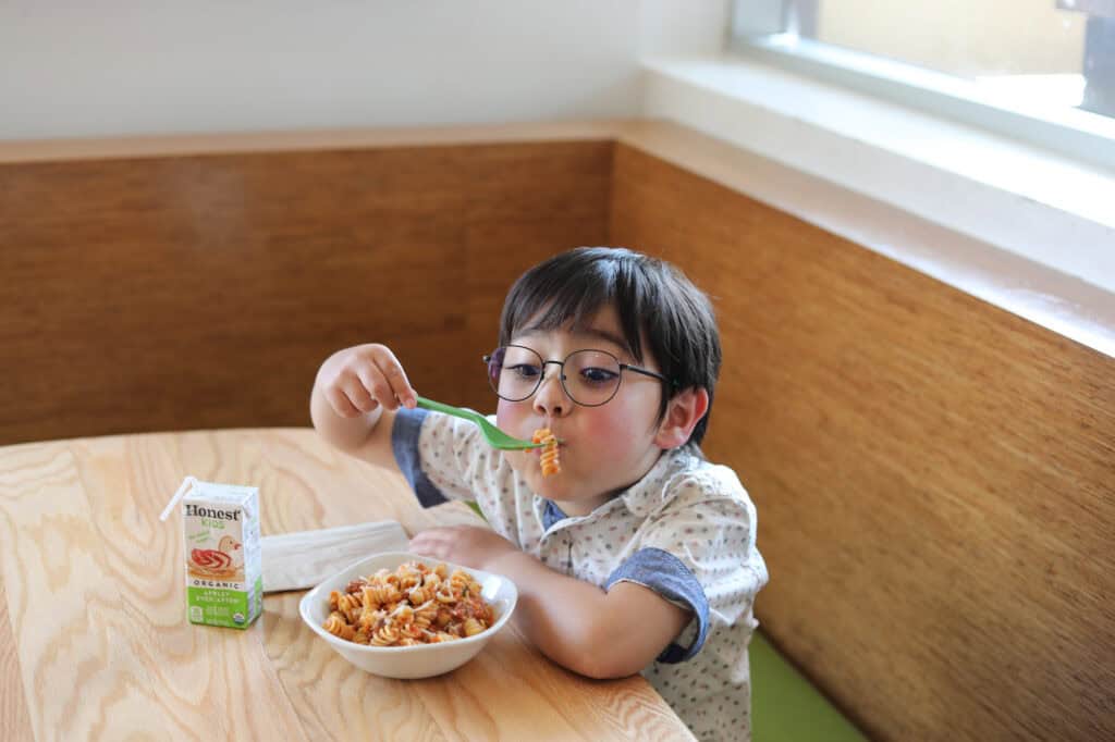 Tender Greens Boy eating pasta 